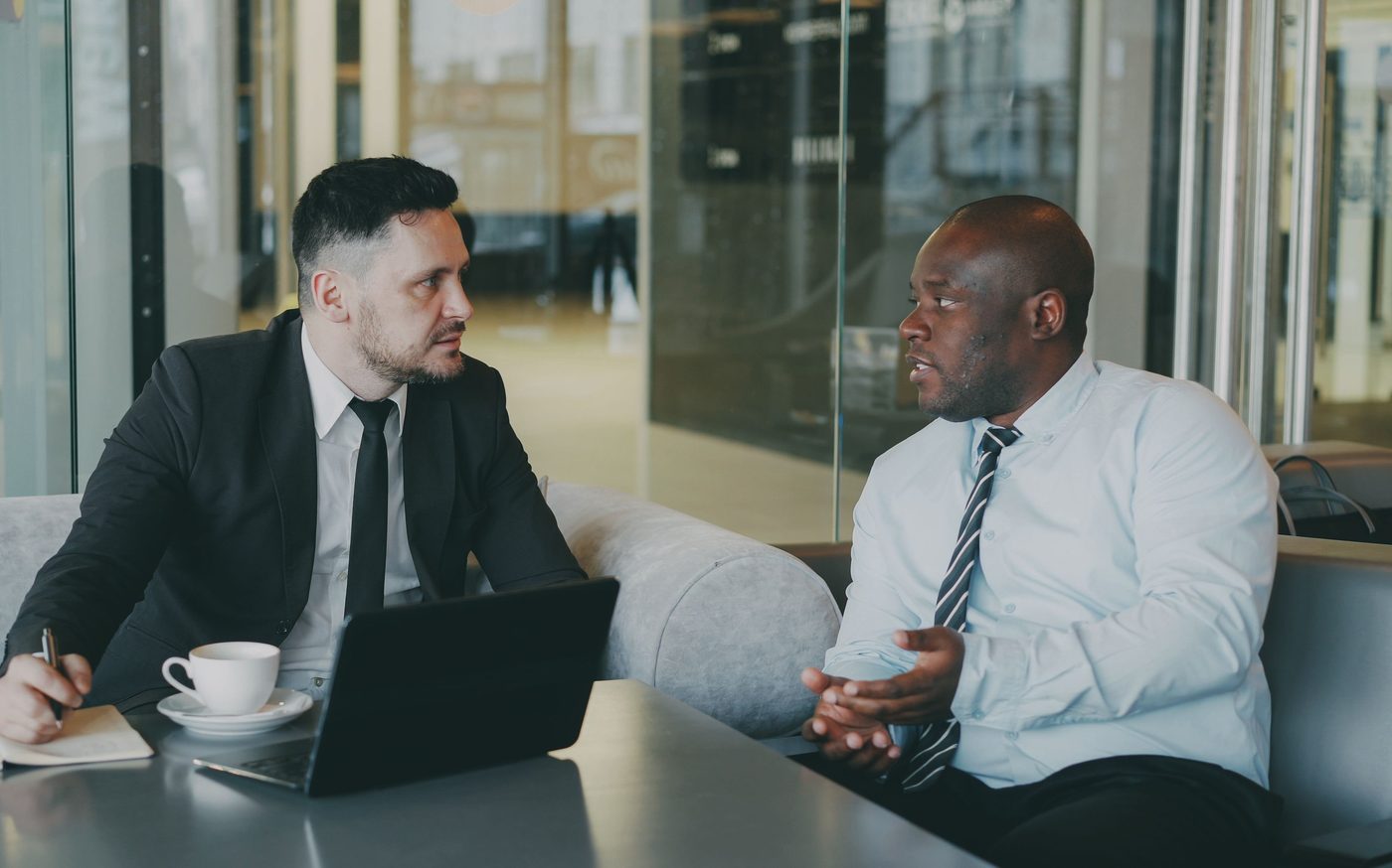 Two advisors in conversation across a table in a bright office